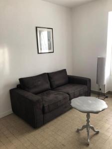 - un salon avec un canapé brun et une table dans l'établissement Appartement proche du PAL, à Dompierre-sur-Besbre
