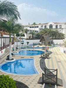 - une piscine avec des palmiers dans un complexe dans l'établissement La Maison Amarilla Golf, à San Miguel de Abona