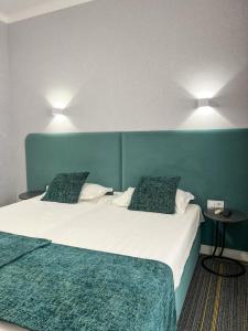 a bedroom with two beds and two lights on the wall at Жемчужина гостиница Балхаш in Balqash +9 photos