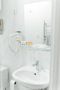 Baño blanco con lavabo y aseo en Жемчужина гостиница Балхаш, en Baljash