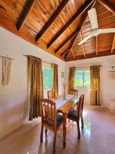 a dining room with a wooden table and chairs at Green's Palace Jamaica in Oracabessa