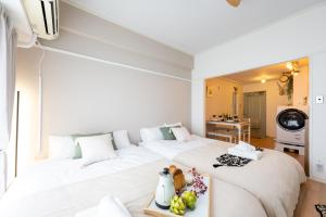 1 dormitorio blanco con 1 cama blanca grande y TV en Beige, en Tokio
