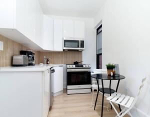 kuchnia z białymi szafkami i stołem z krzesłami w obiekcie 4 BR Luxury Apartment in Tribeca w Nowym Jorku