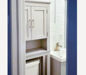 La salle de bains est pourvue d'un lavabo et d'une armoire blanche. dans l'établissement 4 BR Luxury Apartment in Tribeca, à New York