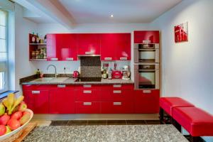 eine Küche mit roten Schränken und einer Schale Obst in der Unterkunft CHAMBRE AU CENTRE VILLE TRES COSY in Nancy