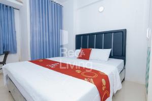 um quarto com uma cama com um cobertor vermelho e branco em Redliving Apartemen Grand Sentraland - AT Properti Tower Pink em Karawang