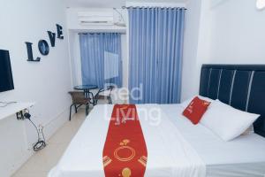 a hotel room with a bed with a red tie on it at Redliving Apartemen Grand Sentraland - AT Properti Tower Pink in Karawang