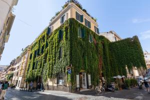 a building covered in green ivy on a street at Domus Suite 14 in Rome
