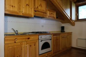 una cucina con armadi in legno e piano cottura. di Anny 16 a Canazei