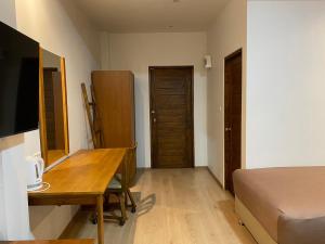 - une chambre avec un bureau et un lit dans l'établissement P Villa Homestay, à Ban Bang Krasan