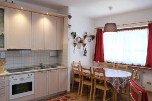 a kitchen with a table and chairs in a kitchen at Al Ruscello in Canazei