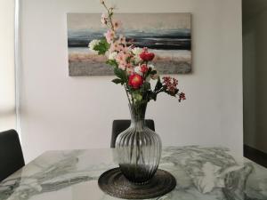 a vase with flowers in it sitting on a table at Habitación privada en zona exclusiva in Panama City