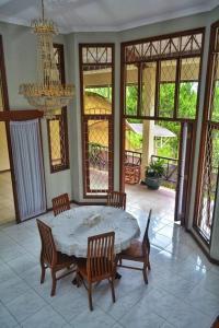 ein Esszimmer mit Tisch und Stühlen und einem Kronleuchter in der Unterkunft Kuca Dago IV in Bandung + 16 Fotos