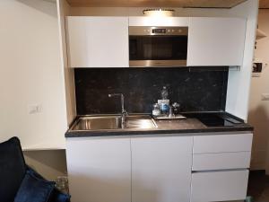 a kitchen with a sink and a microwave at Petit Bijou - Cervinia - BOX AUTO - CIR 0151 in Breuil-Cervinia
