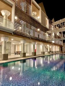 a large swimming pool in a building at night at Sinergi Hotel & Villa in Sengkaling