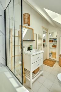 een badkamer met een wastafel en een spiegel bij "Le Beffroi" cocon en hyper centre de Nevers, service premium by PRIMO C0NCIERGERIE in Nevers