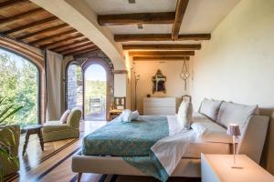 een slaapkamer met een bed en een bank bij Podere Erbolino in Gaiole in Chianti