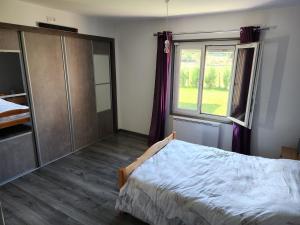um quarto com uma cama e uma grande janela em Villa porte bonheur em Arenthon