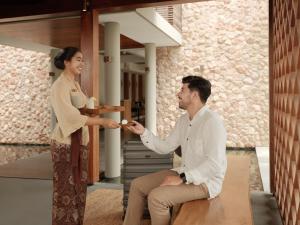 a man handing a woman a piece of food at Chesa Canggu in Canggu