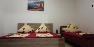a bedroom with two beds with red and white pillows at Apartmani kod Rade in Pakoštane