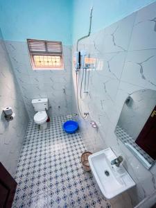 y baño con aseo y lavamanos. en NB MOTEL-KIHIHI, en Kihihi