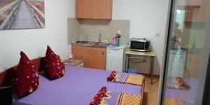 a small kitchen with a table with red pillows at Apartmani kod Rade in Pakoštane