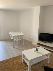 sala de estar con mesa blanca y TV en Apartamento en el centro, en Igualada