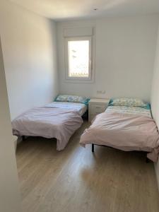 2 camas en una habitación con ventana en Apartamento en el centro, en Igualada