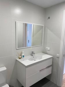 a white bathroom with a sink and a mirror at Apartamento en el Centro in Igualada +5 photos
