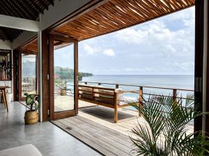 a house with a balcony with a view of the ocean at Bingin High Tide in Uluwatu