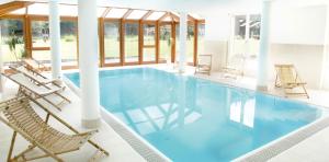 a swimming pool with chairs and a swimming poolvisorvisor at Hotel Im Krummbachtal in Schönau an der Brend