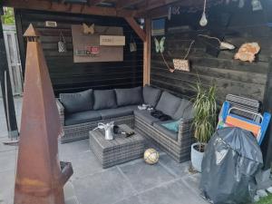 a outdoor patio with a couch and chairs at Leuke tussenwoning in Hoogkarspel