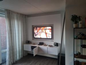 un soggiorno con TV a parete di Leuke tussenwoning a Hoogkarspel