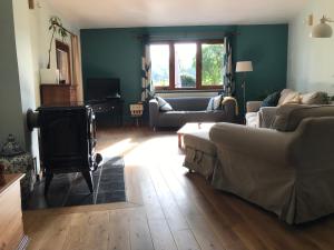 uma sala de estar com um sofá e uma lareira em « Le LoMa » Ancienne fermette em Hotton