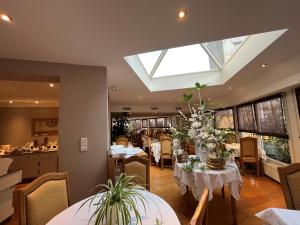 a dining room with tables and chairs and a skylight at Maison LUTETIA R in Strasbourg