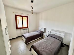 a bedroom with two beds and a window at Appartamento La Rondine in Pignataro Maggiore