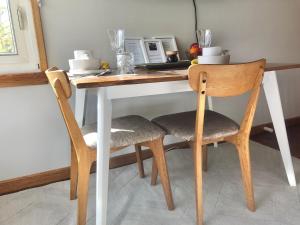 een keukentafel met 2 stoelen en een magnetron bij Lovely Budget Vegan Homestay in Newstead