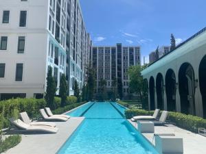 a swimming pool with lounge chairs and buildings at Aspire Ratchada精品公寓 in Bangkok