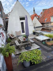 阿爾克馬爾的住宿－Groenlokaal，庭院配有遮阳伞和桌椅。