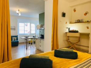 a room with a bed and a kitchen with a table at LE SAINT CYRICE in Rodez