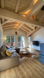 a large living room with a leather couch and wooden ceilings at am Bärgbach DG in Bettmeralp