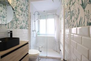een badkamer met een douche, een toilet en een wastafel bij La casita de Lola in Santander