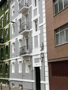 - un bâtiment blanc avec des balcons sur le côté dans l'établissement La casita de Lola, à Santander