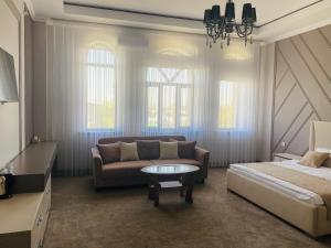 Sala de estar con sofá, cama y mesa en IMPERIAL en Taraz