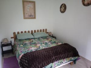 um quarto com uma cama com um edredão em La Cour Angot em Cormeilles