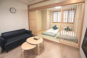 een woonkamer met een bank en een tafel bij 拾野の家 202和室 in Osaka