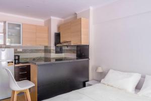 een slaapkamer met een bed en een keuken met een bureau bij Voula's Secret Garden Studio in Athene +6 foto's