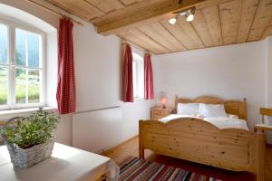 ein Schlafzimmer mit einem Holzbett und einem Fenster in der Unterkunft Selbstversorgerhütte Plafing in Ebbs