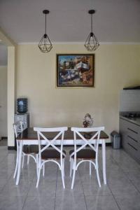 tavolo e sedie in cucina con un'immagine appesa al muro di Kuca Dago VII a Bandung