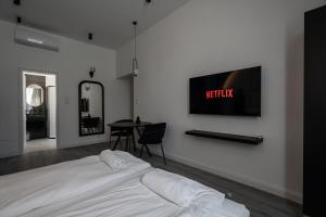 een slaapkamer met een bed en een tv aan de muur bij R6 - Boutique Apartments, Best Location By BQA in Boedapest